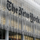 People pass the New York Times building in New York,  Wednesday, Oct. 10, 2012. The New York Times Co.'s stock rose on Thursday, Oct. 11, 2012,  after an analyst raised his rating and price target on the shares. (AP Photo/Richard Drew)